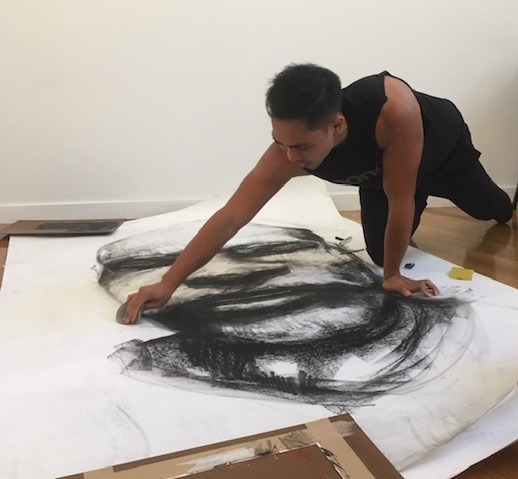 Artist working on a large scale charcoal drawing