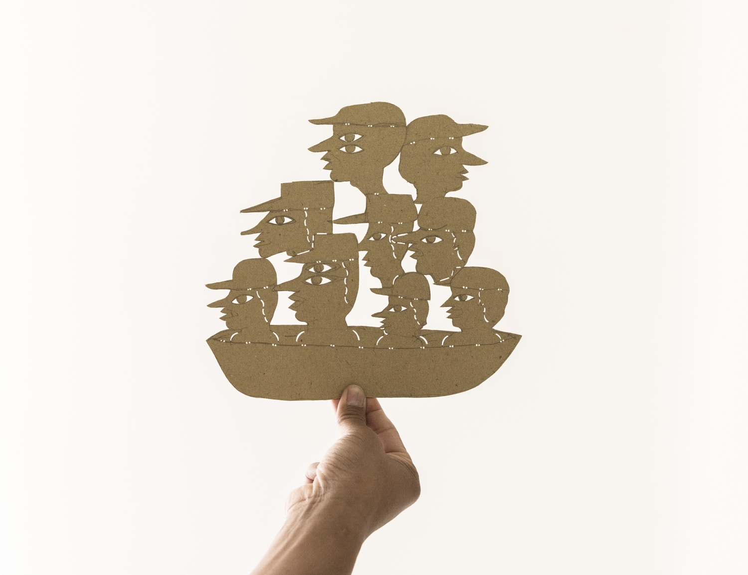 Hand holding up Jumaadi's shadow puppet