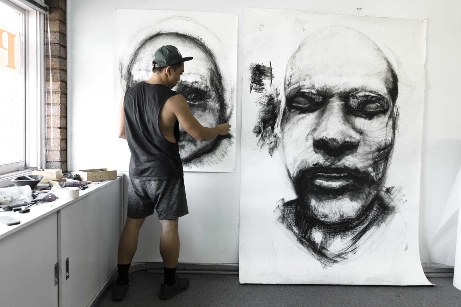 Kristone Capistrano working on his large scale charcoal drawings