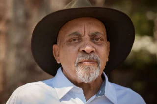 Blacktown Arts mourns the loss of Uncle Greg Simms, a proud Elder of the Gundungurra (Water Dragon / Lizard People) of the Blue Mountains and the Gadigal (Whale People) of the Dharug Nation.  Uncle Greg was a key figure in the Elders in Residence program at The Leo Kelly Blacktown Arts Centre, where Aboriginal Elders lead the way in cultural programming and community connection.  He led community workshops, contributed to exhibitions, and took part in major projects that celebrated and preserved First Nations culture.  Woodcarving was one of Uncle Greg’s great skills and passions, taught to him by his father and grandfather and carried with him throughout his life. His carvings were a way of sharing culture, teaching young people, and giving back to the community.  His legacy lives on in the spaces he helped create, of welcome, learning and shared responsibility.  Our deepest condolences to Uncle Greg’s family and friends.  --- 
Image: Uncle Greg Simms, 2023, photography by Eliya Cohen, Mosca Media Australia