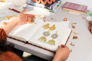 Admire your treasured object for years to come with the Printed Treasures workshop! 
Makers Space artist, Monica Rani Rudhar, will guide young makers through creatively using line, shape and colour to create a printed artwork in this school holiday workshop. 
No experience needed and all materials provided. 
Make sure to bring an object you or a young participant wish to focus on. 
Book now via link in bio. 
@blacktowncitycouncil @creatensw @monicaranirudhar 
#BlacktownArts #BlacktownCityCouncil #SchoolHolidays #Workshop #PrintArtwork  --- 
Image: Monica Rani Rudhar’s artbook in studio, 2025, photography by Garry Trinh  ID: Image shows Monica looking through her artist notebook with sketches and drawings of jewellery, in her studio