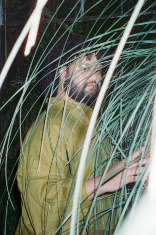 Sione Tuʻívailala Monū is an interdisciplinary artist of Tongan descent whose practice spans photography, performance, adornment and installation, exploring identity, family and the Pasifika queer diaspora.  Drawing on the Tongan art of flower design (nimamea‘a tuikakala), Monū reimagines tradition through found and everyday materials.  In their workshop, participants will create Kahoa, traditional Tongan garlands or necklaces, using dollar-store and found materials. The works will adorn the gallery as part of the Blacktown Garage Party installation, with participants invited to photograph themselves wearing their creations before they become part of the space.  Workshops: Thursday 8 and Friday 9 January 
Blacktown Garage Party: Thursday 15 and Friday 16 January 
@blacktowncitycouncil @powerhouse @sydney_festival @sione_has_doubts  #BlacktownArts #BlacktownCityCouncil #BlacktownGarageParty #Free #Workshops  ---
Image: Sione Monu, 2023, photo by Peter Wing
ID: Image showcases artist, Sione Monu, behind foliage with flash being used